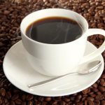 Чашка крепкого кофе на фоне кофейных зерен