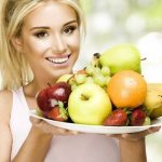 Девушка держит блюдо с фруктами и ягодами