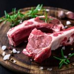 два сырых кусочка баранины с солью, перцем и зеленью