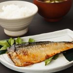 копченая скумбрия на тарелке с зеленью