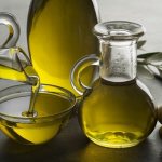 оливковое масло в графина и пиале, три свежие оливки