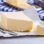 разрезанный кусочек сливочного масла на столе