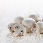 свежие шампиньоны на деревянной поверхности